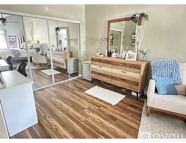A bedroom with a dresser and mirror.
