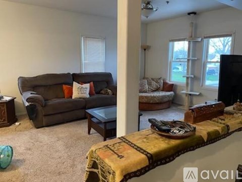 A living room with a brown couch and a yellow blanket on the coffee table.