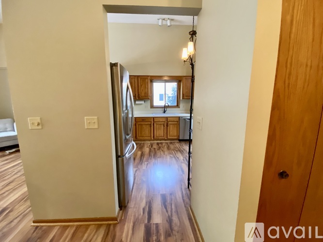 A kitchen with wooden floors and a refrigerator.