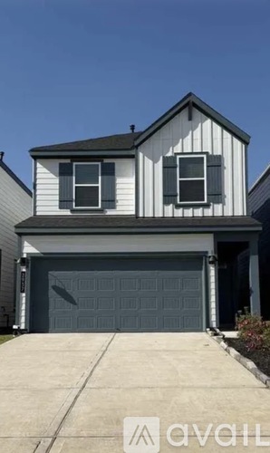 A two-story house with a garage door and a driveway.