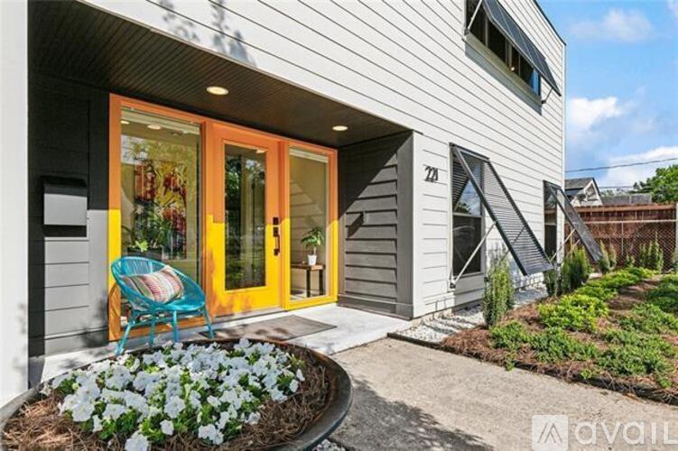 A house with a grey exterior and a yellow door.