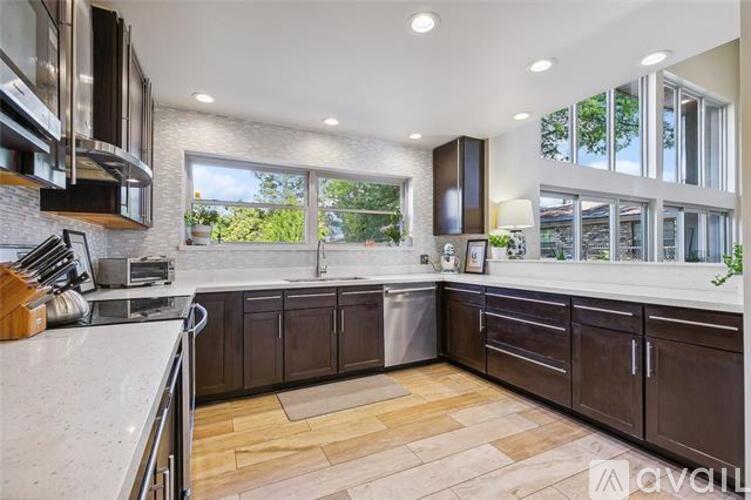 A modern kitchen with dark brown cabinets and a large island.