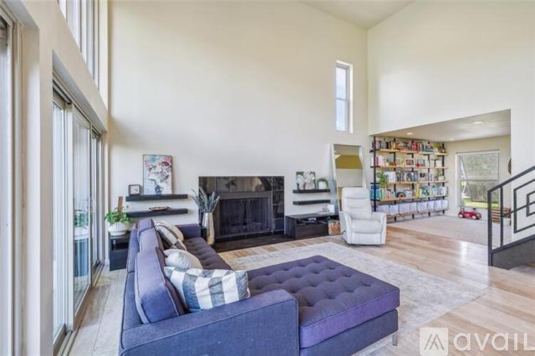 A living room with a purple couch and a fireplace.