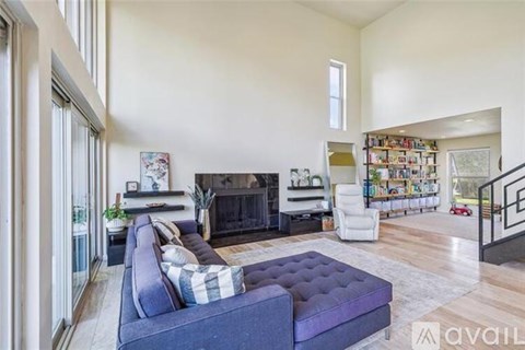 A living room with a purple couch and a fireplace.