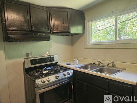 A kitchen with black cabinets and a stove top oven.