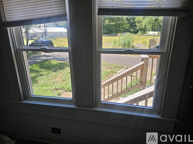 A window with a view of a car and a house.