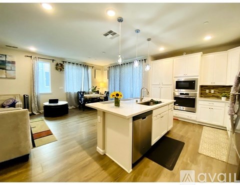 A modern kitchen with white cabinets and a central island.