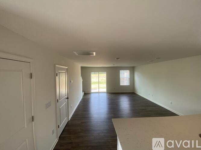 A spacious room with wooden floors and white walls.