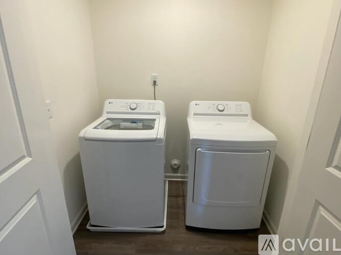 Two white front loading washing machines in a small laundry room.