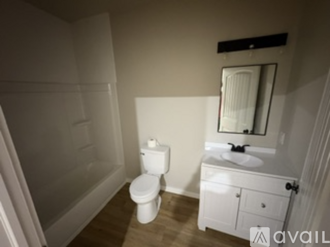 A white toilet sits next to a sink in a small bathroom.