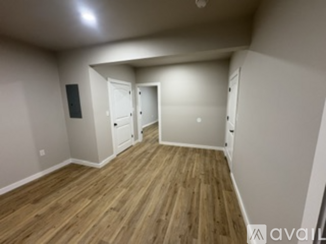 A room with wooden flooring and white walls.