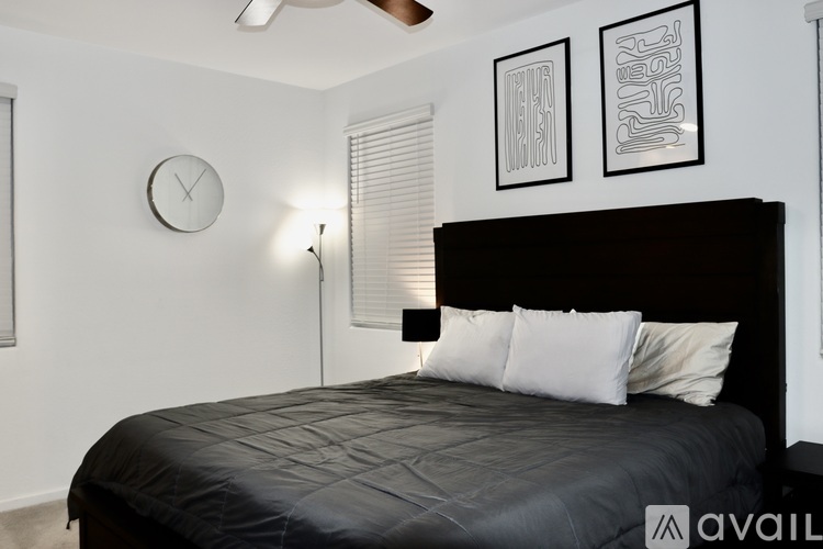 A bedroom with a large bed and two framed pictures on the wall.