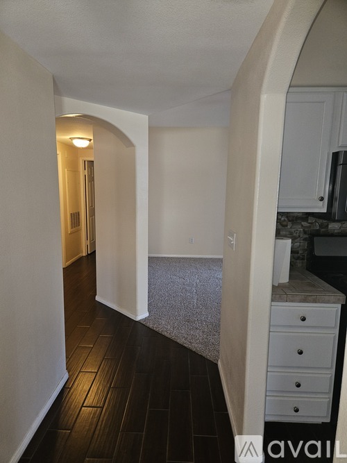 A hallway with a white door and a counter with a sink.
