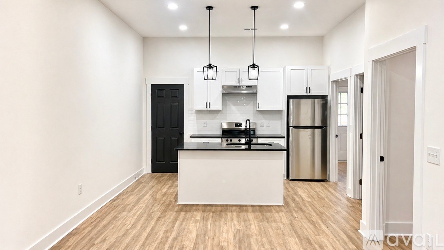 A modern kitchen with white cabinets and a black refrigerator.
