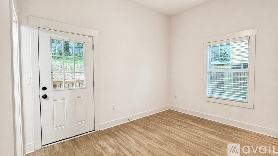 A room with a door and a window with blinds.