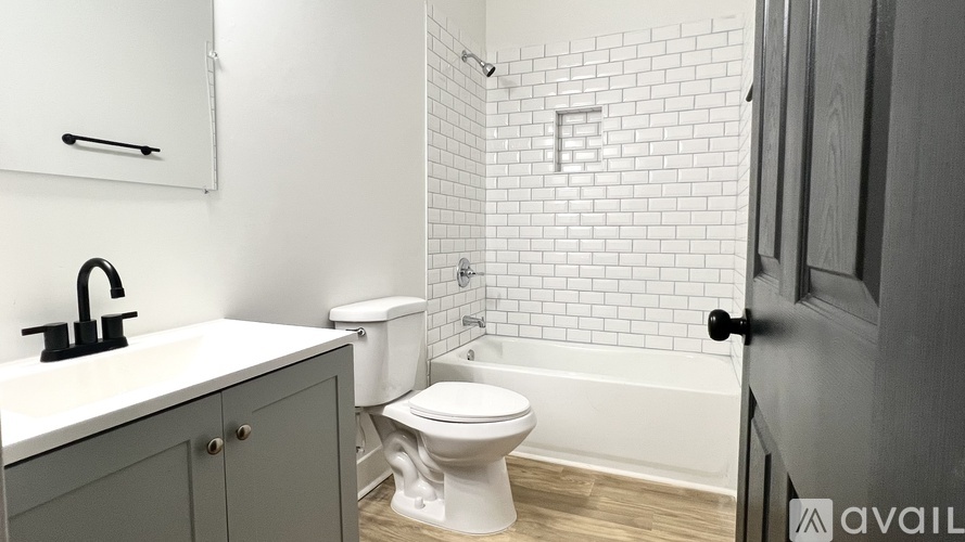 A bathroom with a white toilet and a white tiled shower area.