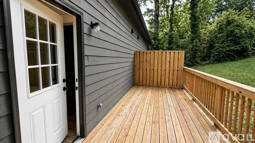 A wooden deck with a white door and a window.