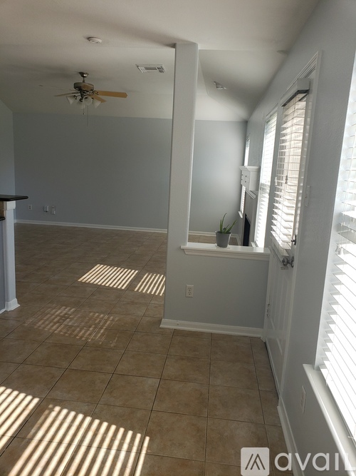 A room with a ceiling fan and tiled floor.