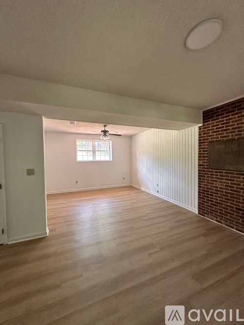 A room with wooden flooring and a ceiling fan.