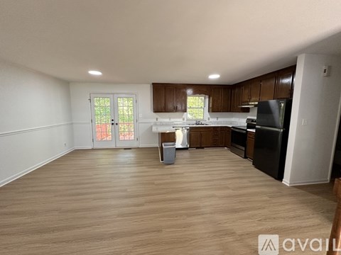 A kitchen with wooden cabinets and a black refrigerator.