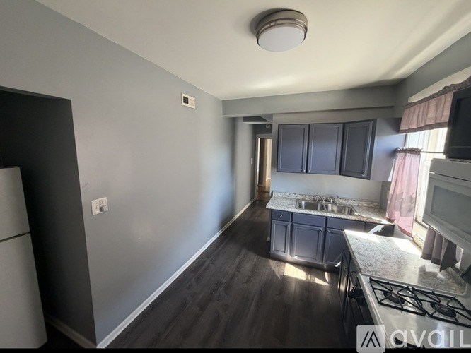 A kitchen with a stove top oven and a refrigerator.
