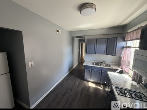 A kitchen with a stove top oven and a refrigerator.