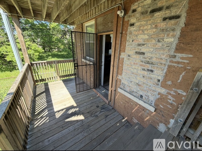 A wooden deck with a brick wall and a door.