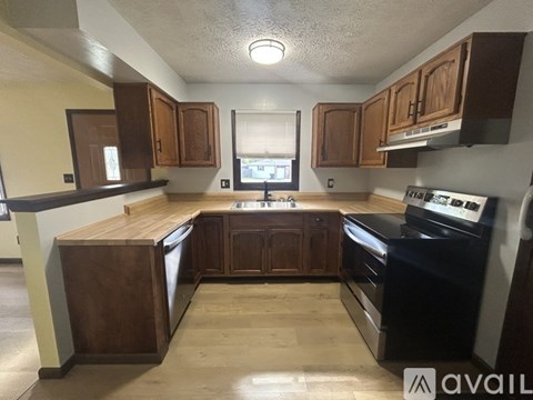 A kitchen with wooden cabinets and black appliances.