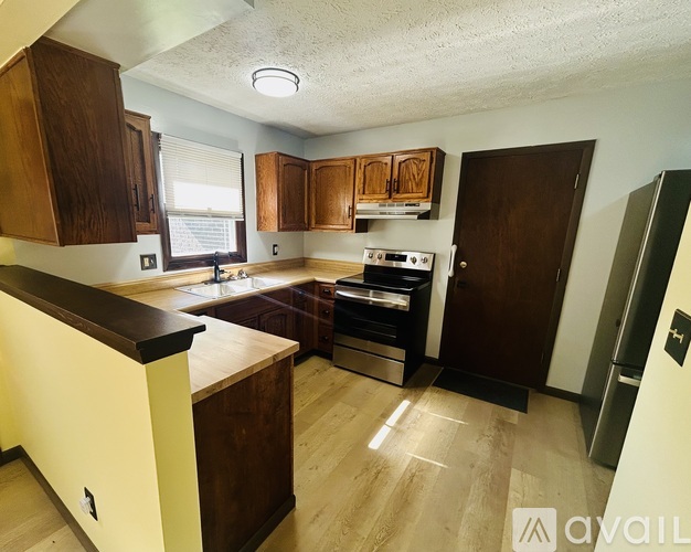 A kitchen with wooden cabinets and a stove top oven.
