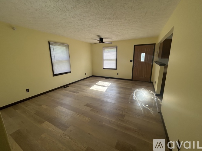 A room with wooden flooring and a ceiling fan.