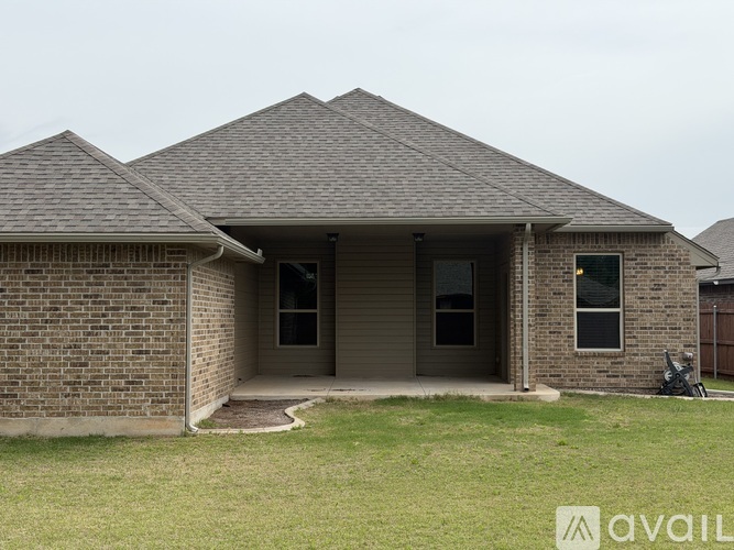 A house with a brick exterior and a pitched roof is available for sale.