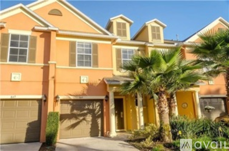 A yellow house with a palm tree in front.