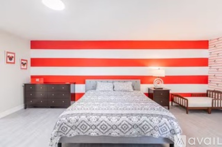 A bedroom with a large bed and a dresser with a mirror.
