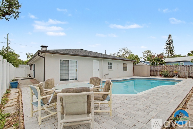 A house with a pool and patio furniture.