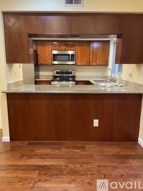 A kitchen with wooden cabinets and a granite countertop.