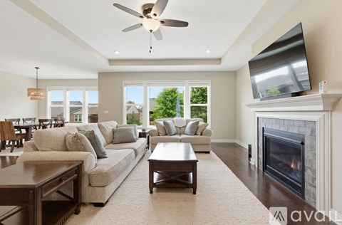 A living room with a fireplace and a television on the wall.