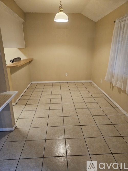 A room with tiled flooring and a window with curtains.
