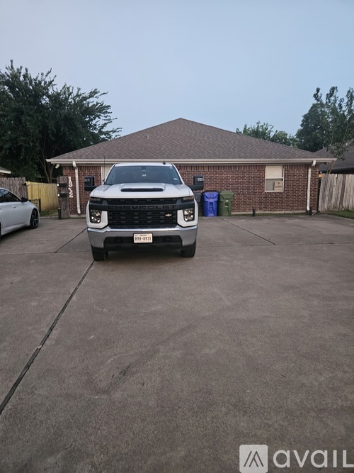 A black pickup truck is parked in a driveway.