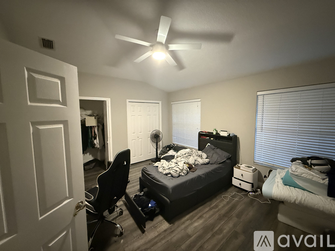 A bedroom with a bed, desk, and chair.