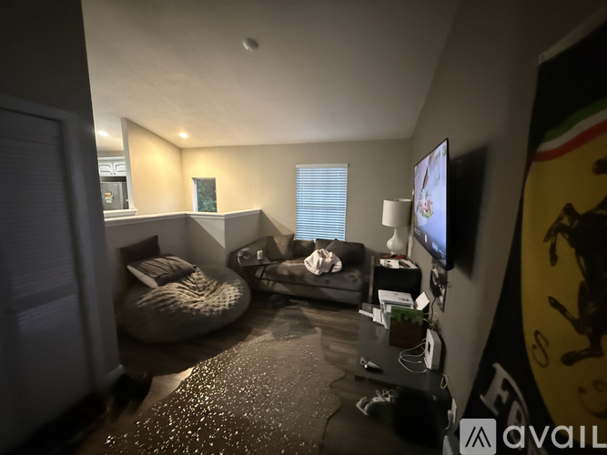 A living room with a bean bag chair and a flat screen TV.