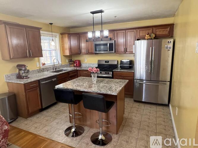 A kitchen with a granite countertop and stainless steel appliances.
