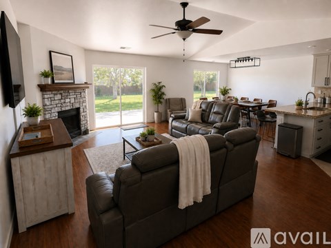 A living room with a grey couch and a ceiling fan.