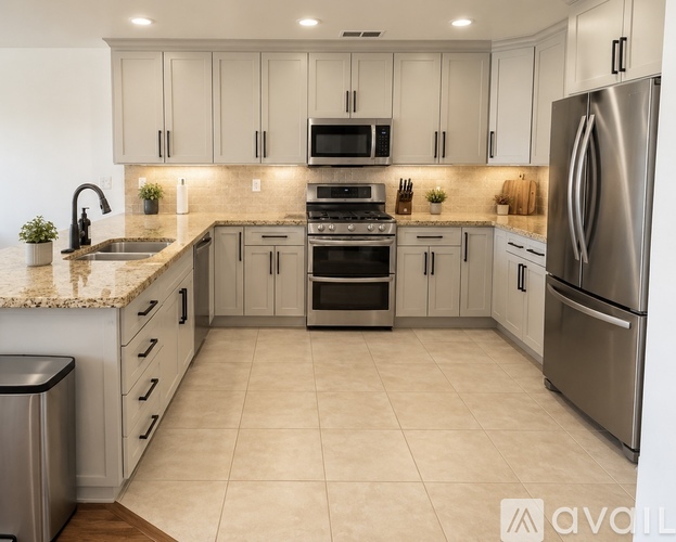 A kitchen with a refrigerator, oven, and microwave.