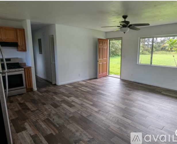 A room with wooden flooring and a ceiling fan.