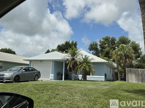 A car is parked in front of a house with a garage.