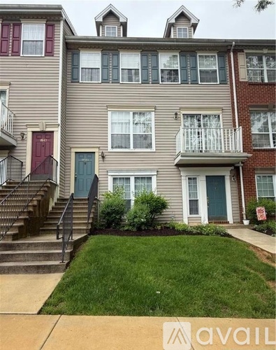 A two-story apartment building with a green lawn in front.