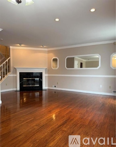 A spacious living room with a fireplace and hardwood floors.