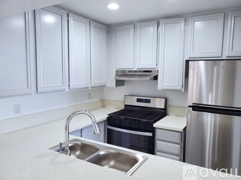 A kitchen with white cabinets and stainless steel appliances.