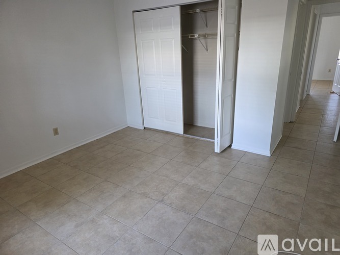 A kitchen area with a white door and a white fridge.