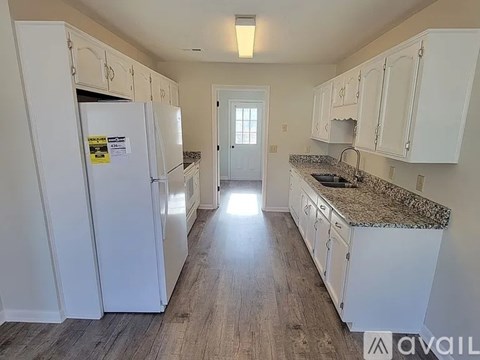 A kitchen with white cabinets and a granite countertop.